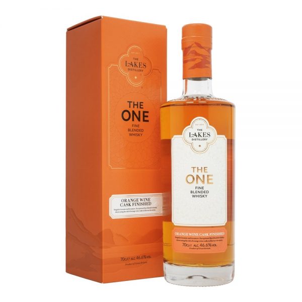 A clear glass bottle of The Lakes orange wine cask finished whisky. Next to the bottle is a bright orange presentation box with black lettering.